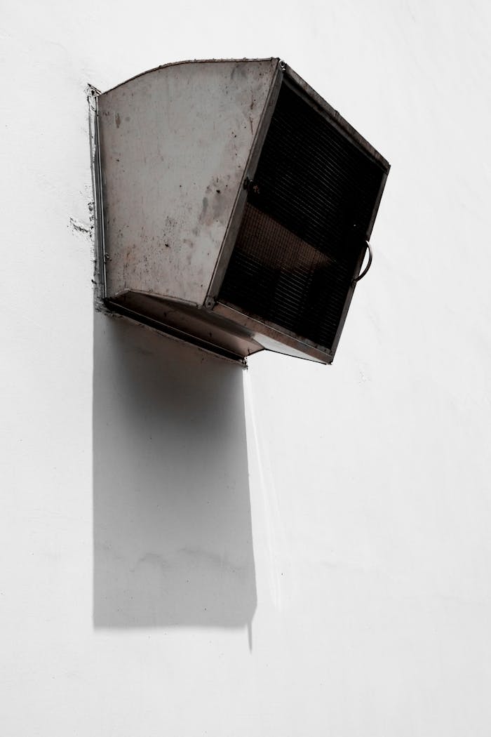 creative-02 A minimalist ventilator casting dramatic shadows on a white wall in urban Taipei.