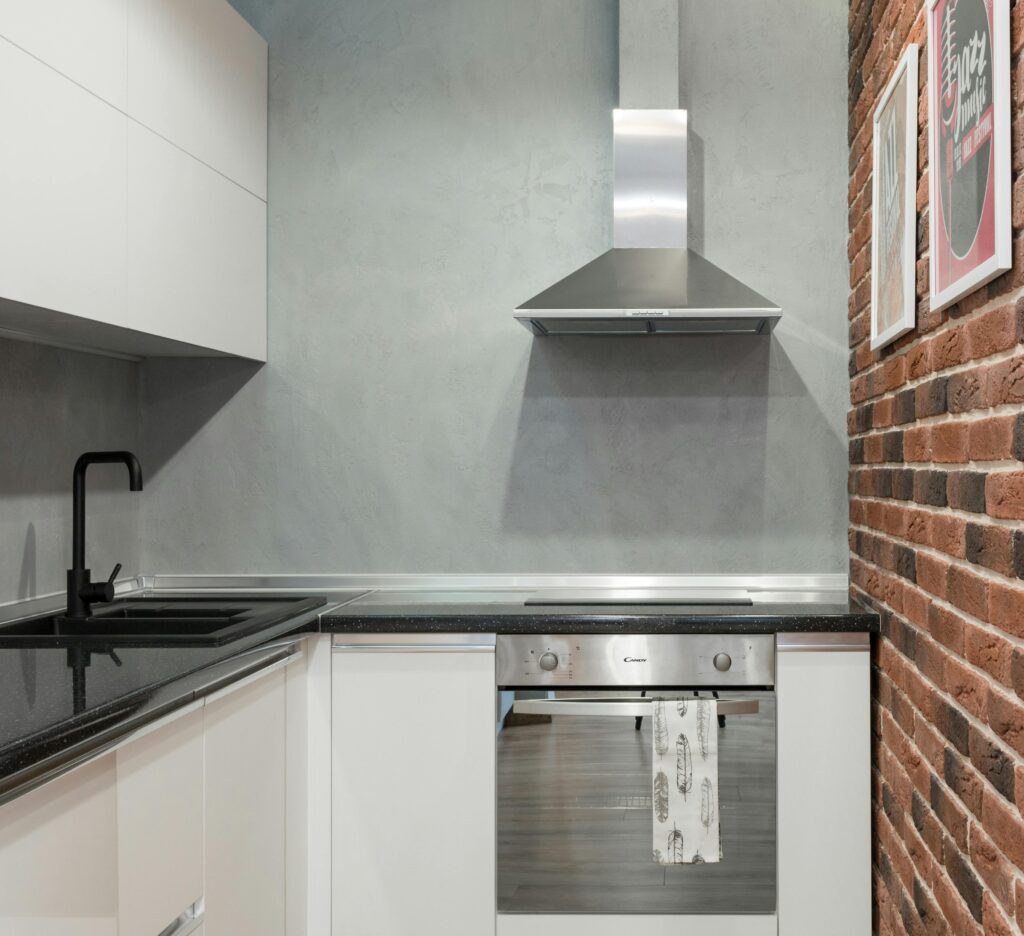 pexels photo 7214729 7214729 Contemporary kitchen interior with stainless steel appliances and brick wall.
